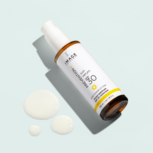 Skincare serum bottle with droplets on a light blue background